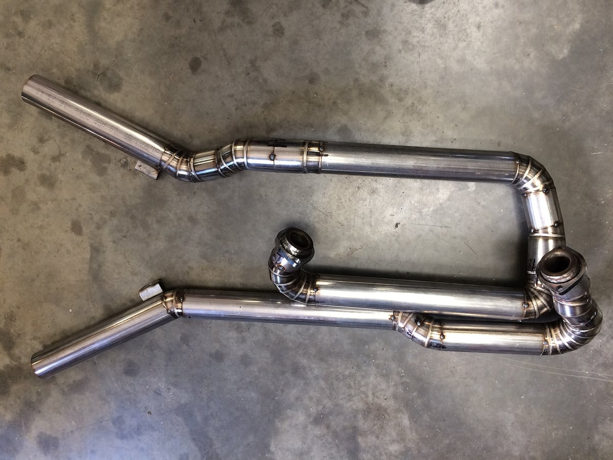 Welded stainless tube assemblies laid out on a shop floor, heat tint colouring the joints — representative imagery, not a specific Late Night Fabrication job